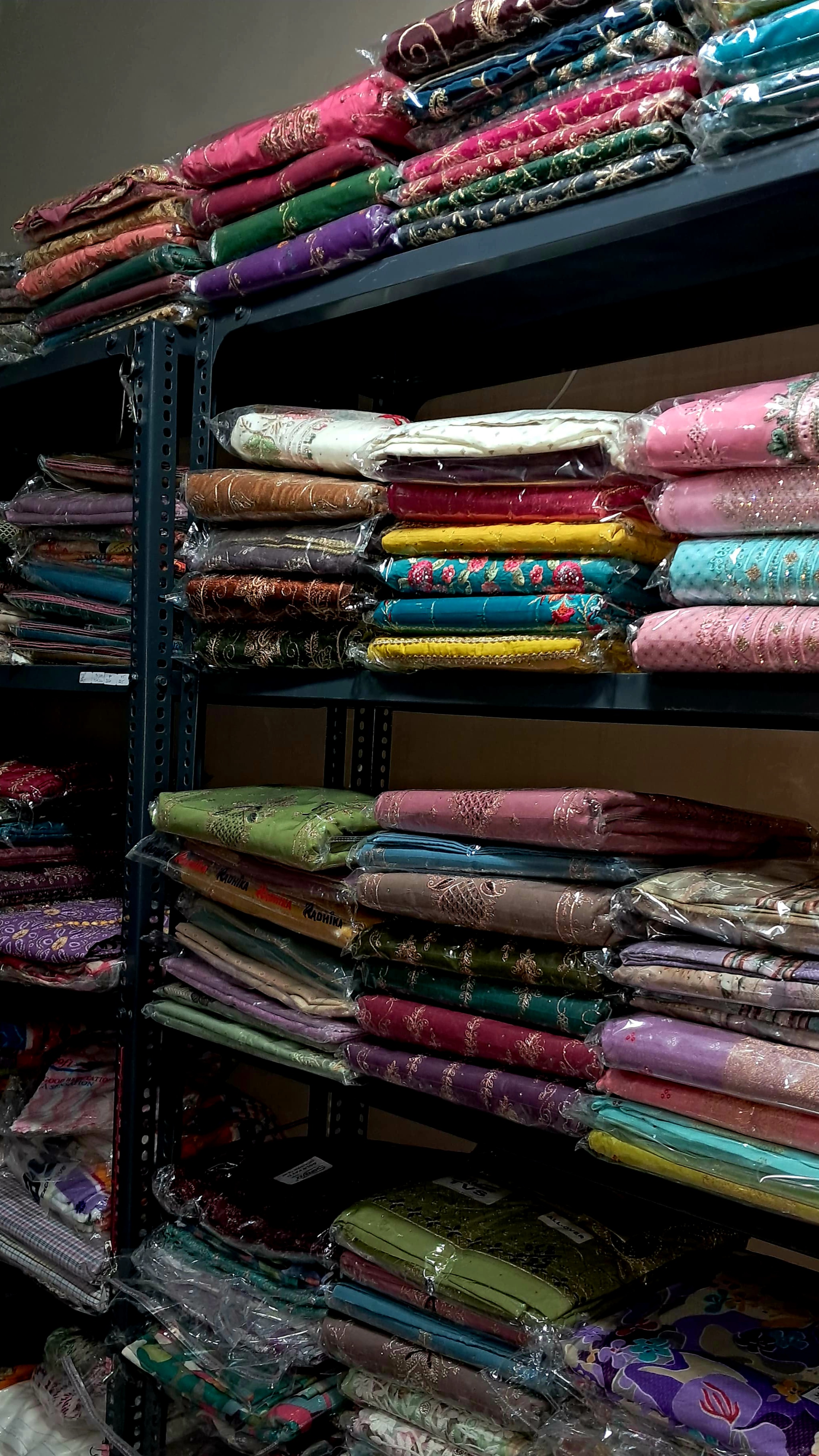 JK Fashion House shelves stacked with vibrant Punjabi suit and kurta pajama fabrics — Ibrahimpur, Punjab